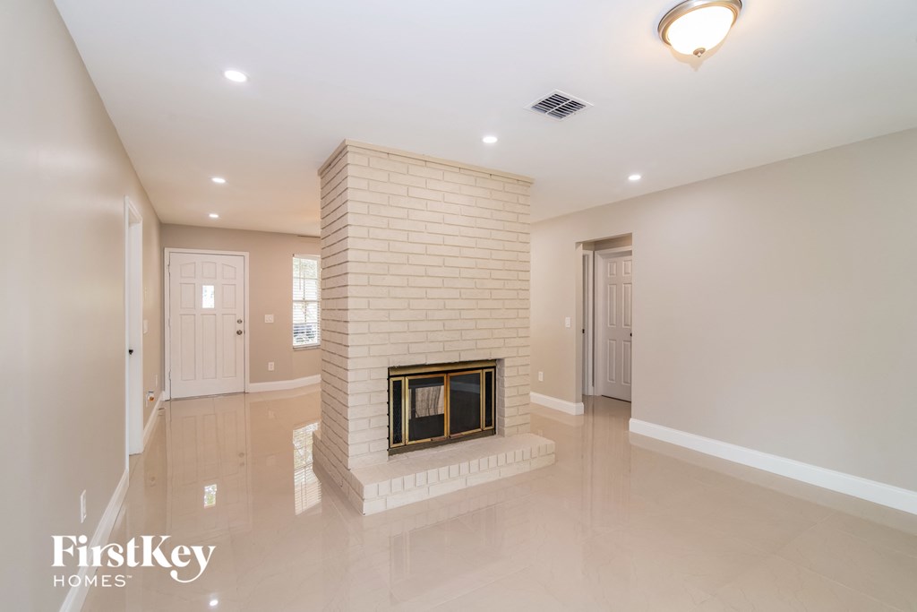 A spacious room with a fireplace and a logo that reads "FirstKey Homes".