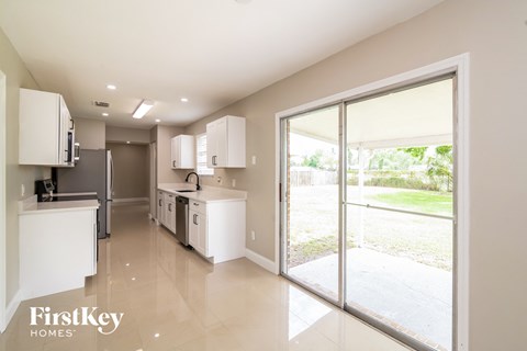 A kitchen with white cabinets and appliances in a house.