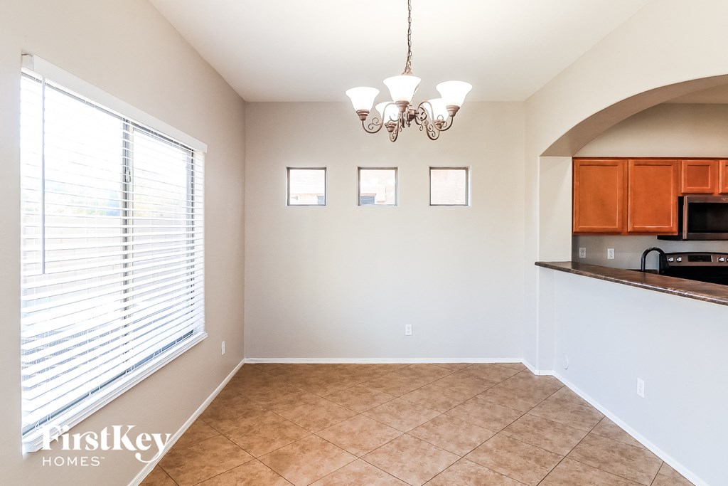 a dining room with a large window and a kitchen