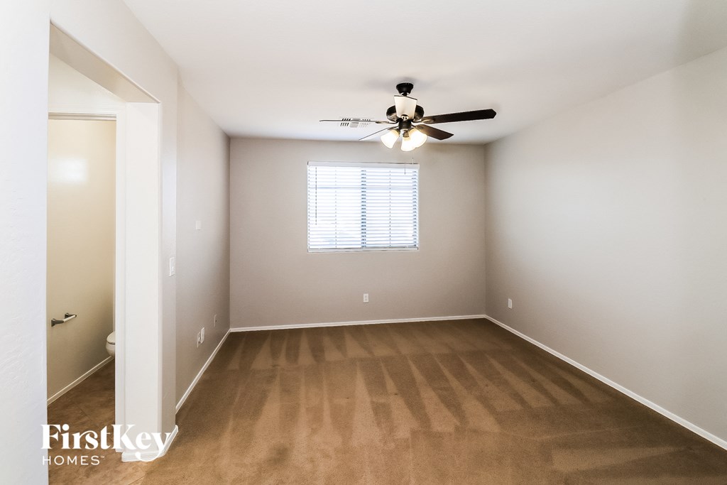 an empty room with a ceiling fan and a window