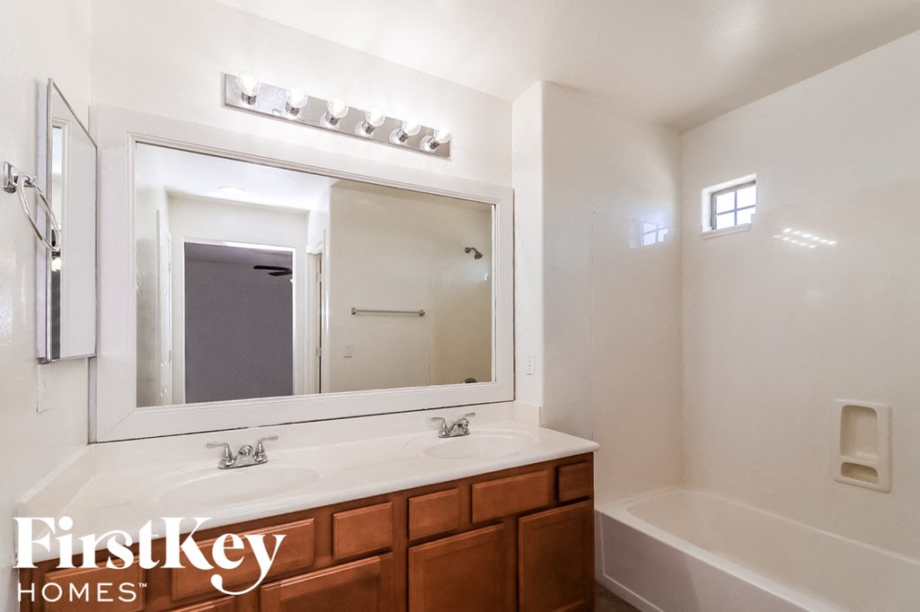 a bathroom with a sink and a mirror and a bath tub