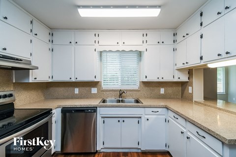A kitchen with white cabinets and a stainless steel dishwasher.