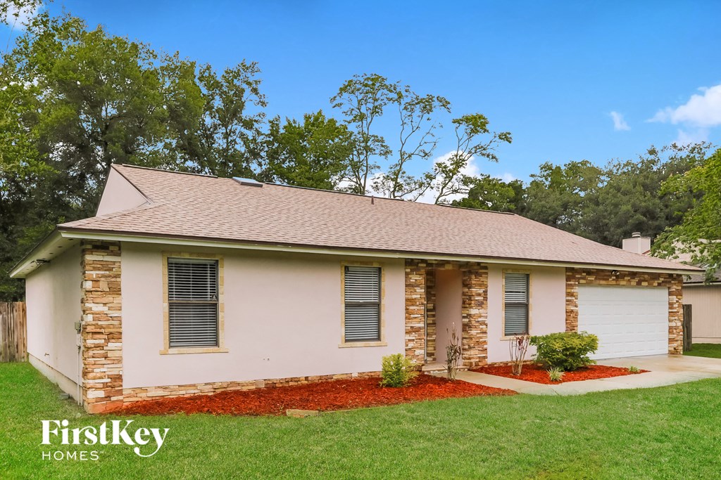 a small white house with a lawn and a driveway