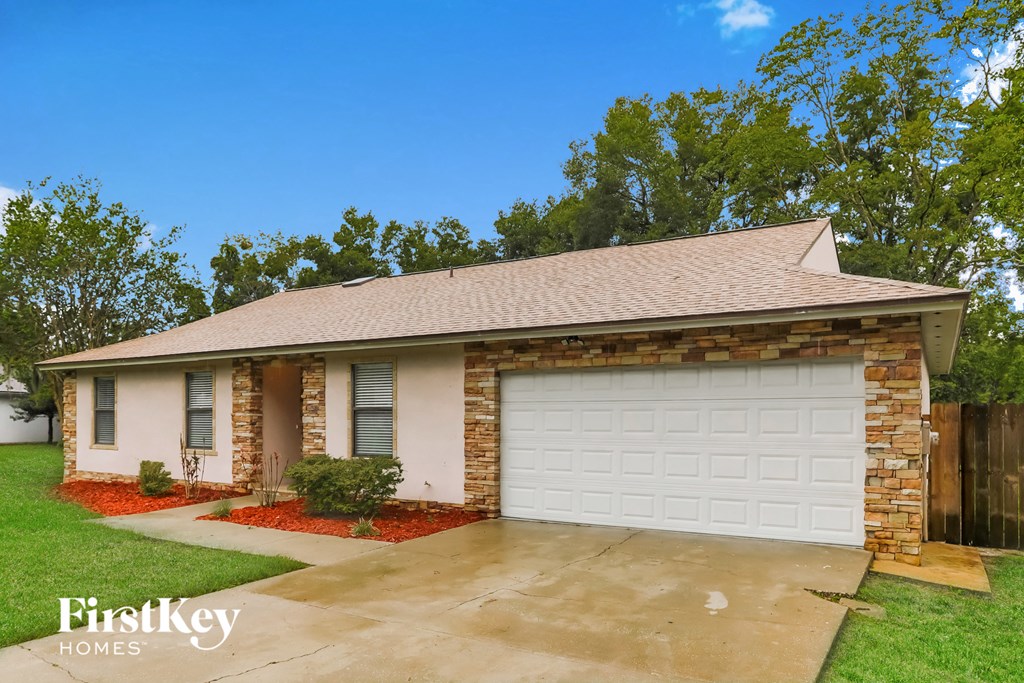 a small brick house with a white garage door