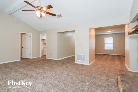 a living room with carpet and a ceiling fan