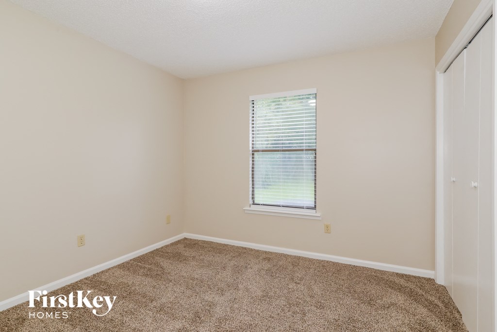 a spacious room with carpet and a window