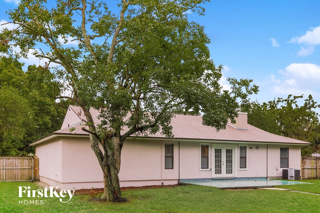 a pink house with a tree in the yard