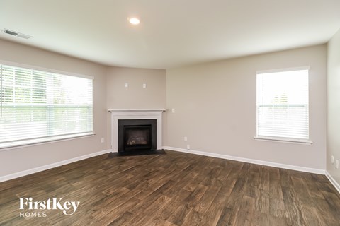 A room with a fireplace and wooden floors.