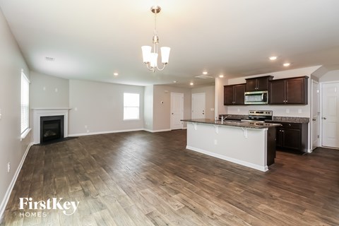 A spacious kitchen and living room with wooden floors and a fireplace.