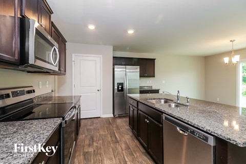 A kitchen with a stainless steel dishwasher and a microwave above the stove.