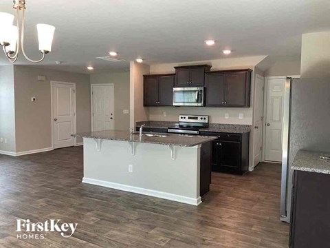 A kitchen with a white island and dark brown cabinets.