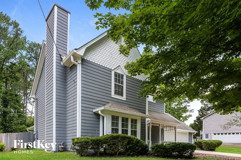 a with white trim and a tree in front of it