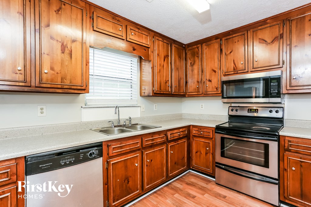 a kitchen with wooden cabinets and appliances and a sink