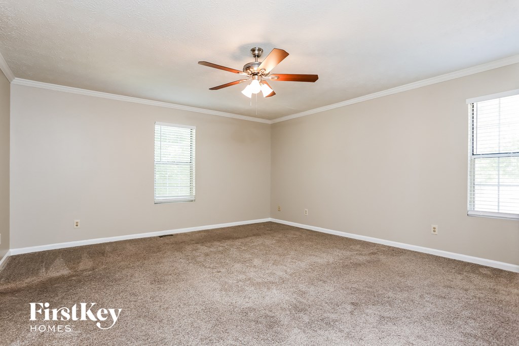 a living room with carpet and a ceiling fan