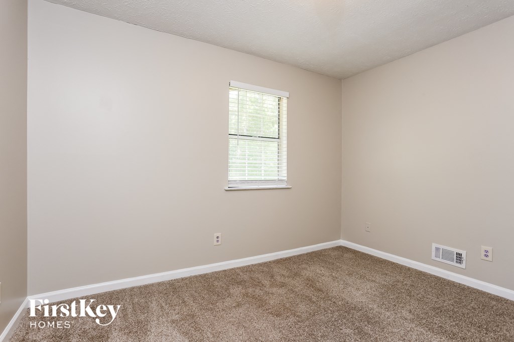 a bedroom with carpet and a window