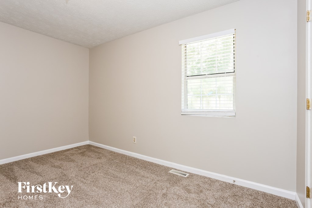a bedroom with carpet and a window