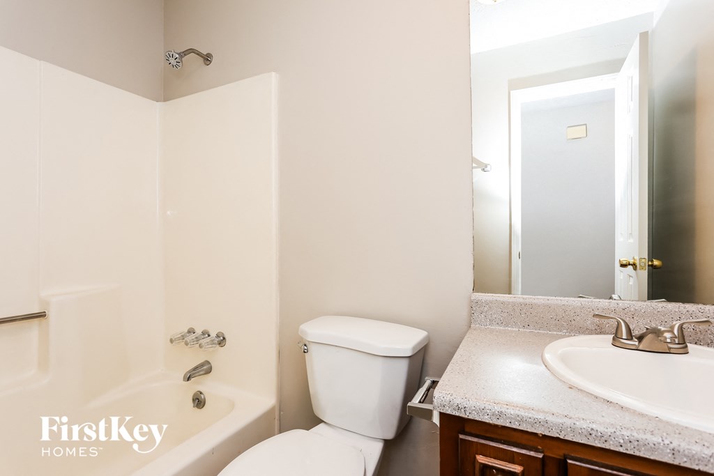 a bathroom with a toilet sink and tub and a mirror