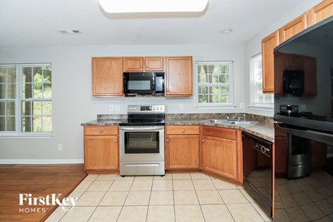 A kitchen with wooden cabinets and a stainless steel oven.