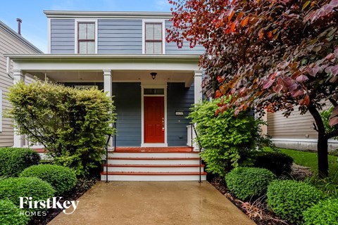the front of a blue house with a red door
