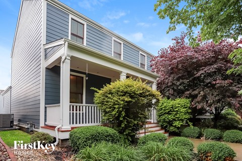 a blue house with a porch and a garden