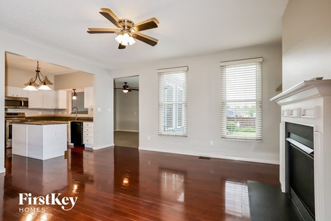 an empty kitchen and living room with a ceiling fan