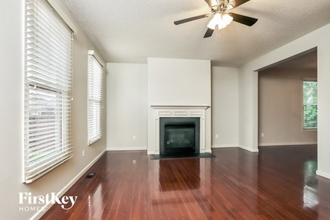 an empty living room with wood floors and a fireplace