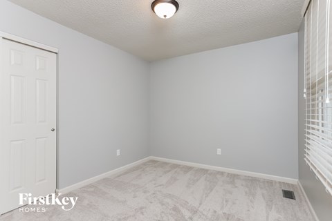 the living room of an empty house with a window and a door