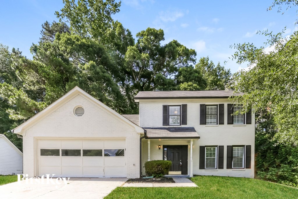 a white house with black shutters and a lawn
