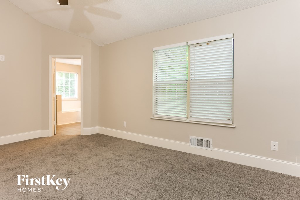 a bedroom with a carpeted floor and a large window