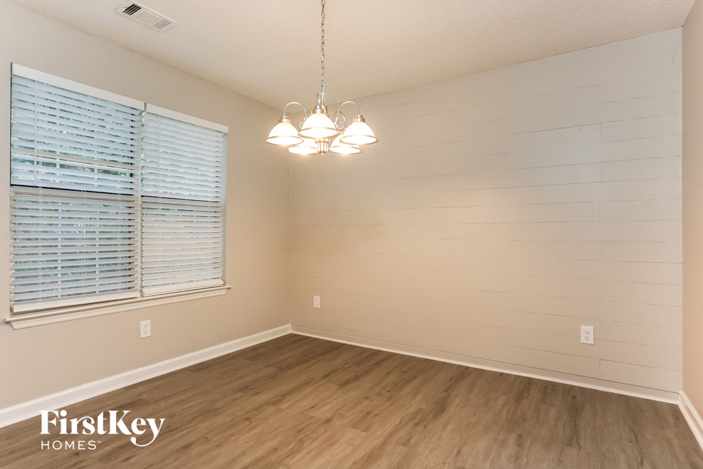 the spacious living room with wood flooring and a large window