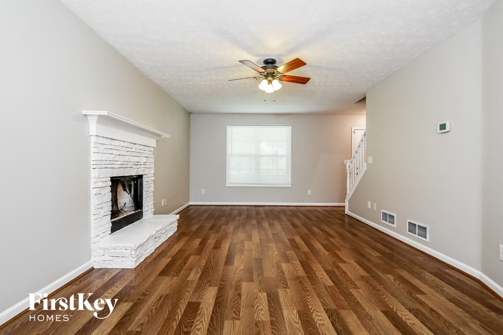 a living room with a fireplace and a ceiling fan