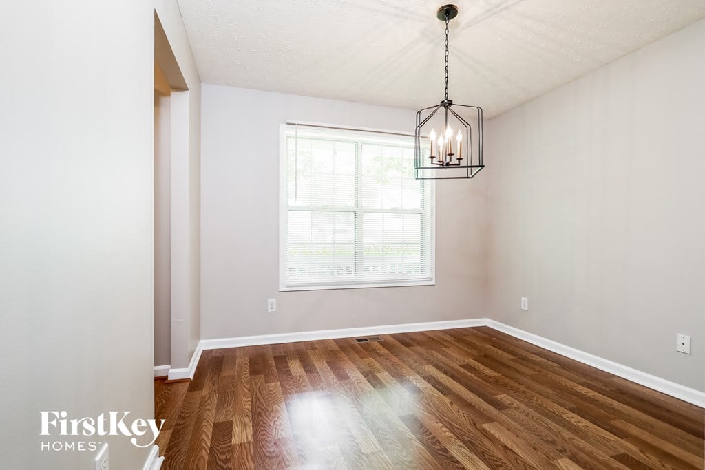 a living room with hardwood floors and a window and a chandelier