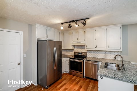 a kitchen with stainless steel appliances and white cabinets