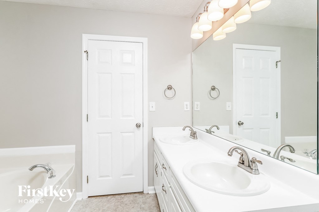 a white bathroom with two sinks and a mirror