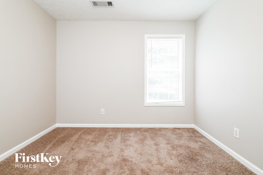 a empty room with carpet and a window