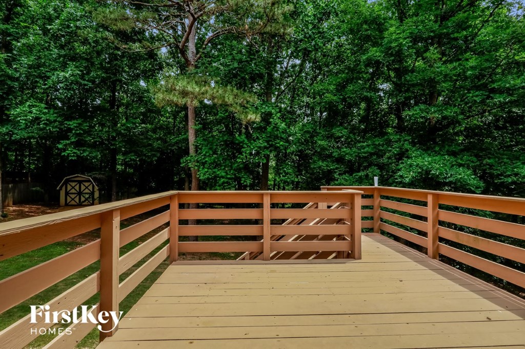 a wooden deck with trees in the background