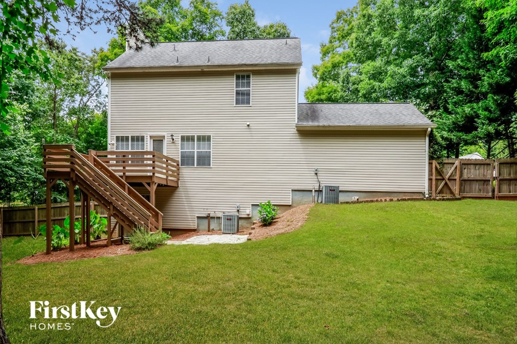 the back of a house with a yard and a deck