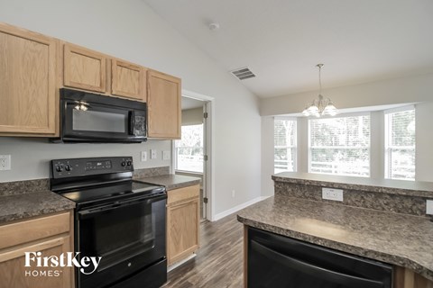 A kitchen with wooden cabinets and a black stove top oven.