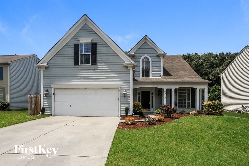 a blue house with white siding and a white garage door