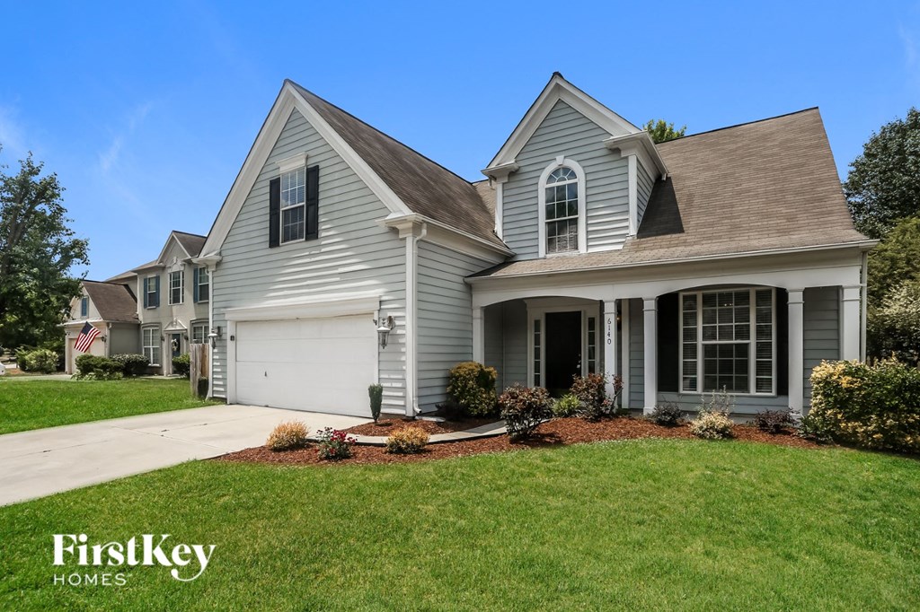 a white house with a lawn and a driveway