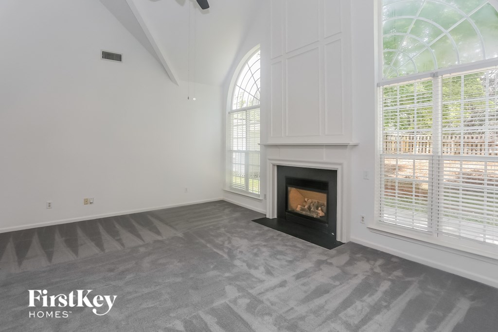 the living room has a fireplace and large windows