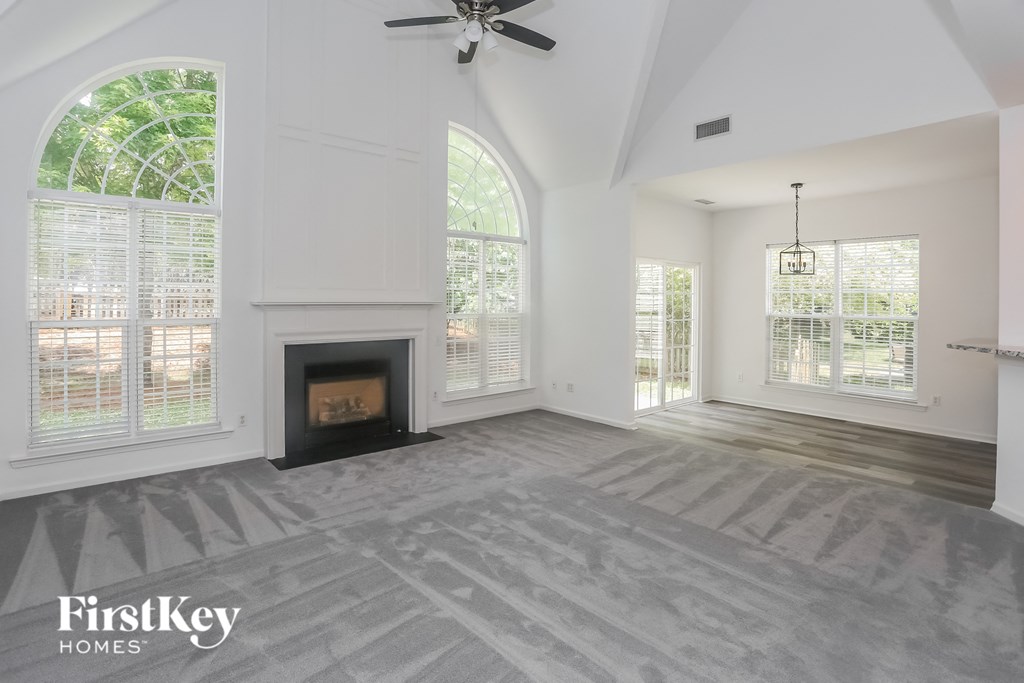 the living room has a fireplace and large windows