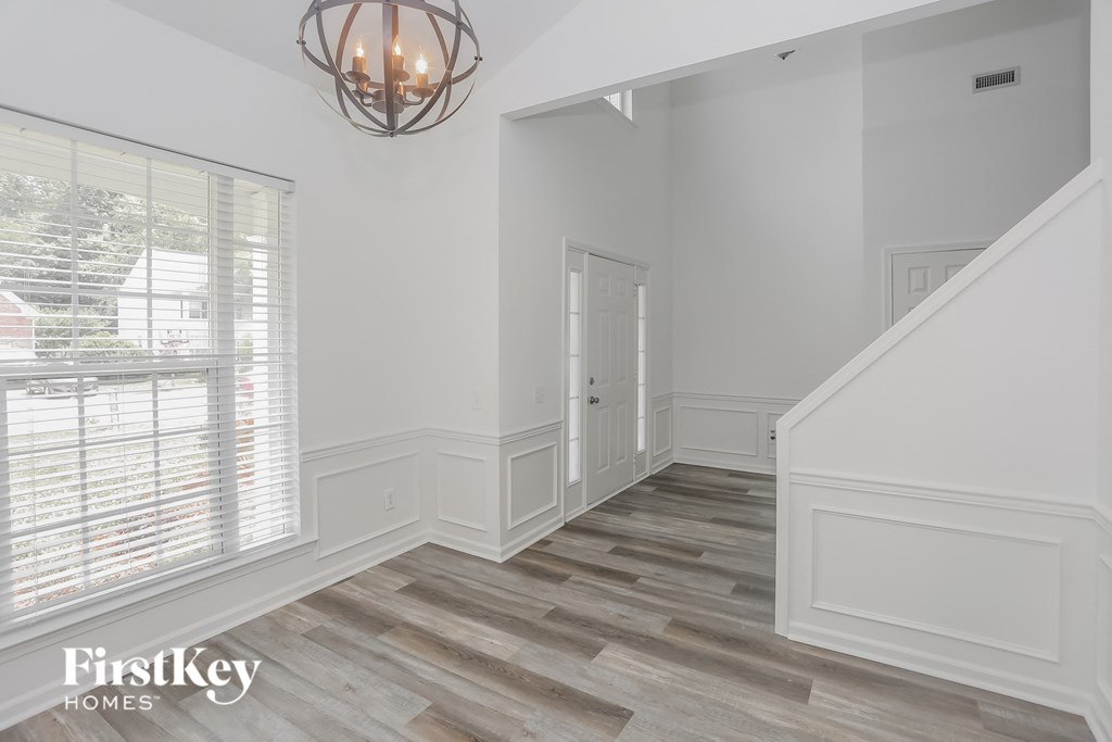 a renovated living room with white walls and wood flooring