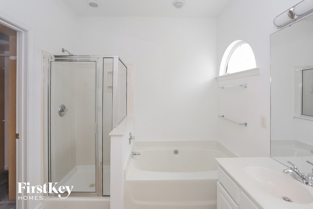 a white bathroom with a shower and a tub and a sink