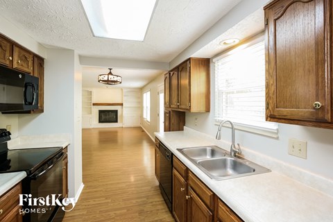 A kitchen with wooden cabinets and a black countertop.