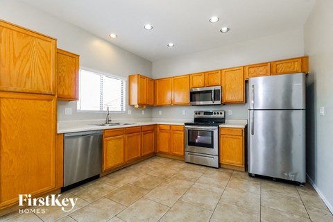 A kitchen with wooden cabinets and a stainless steel refrigerator.