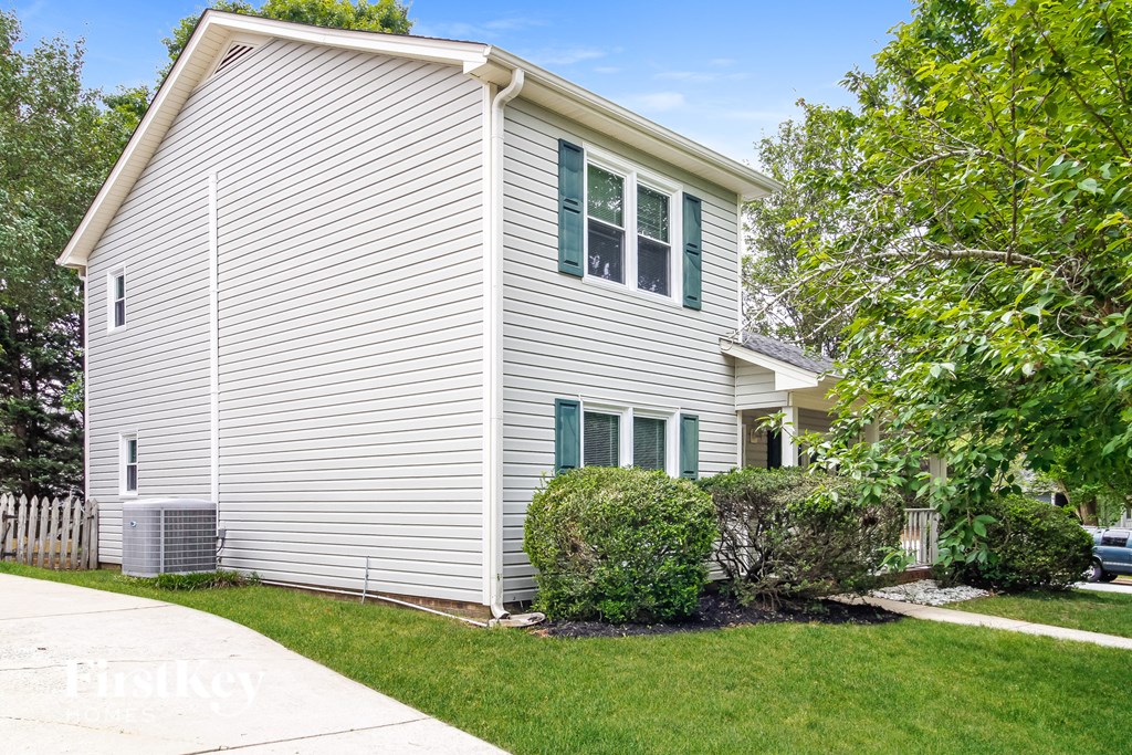 A house with a grey siding and green shutters.