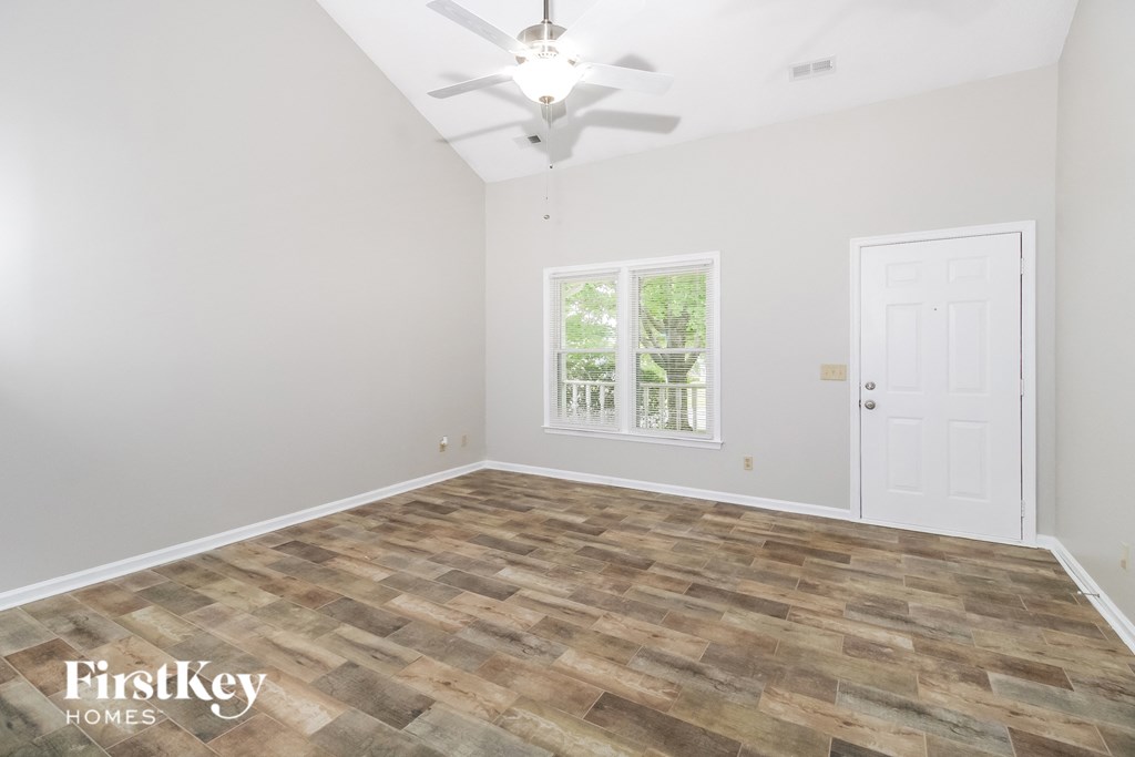 A room with a wooden floor and a ceiling fan.