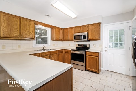 A kitchen with wooden cabinets and a white countertop.