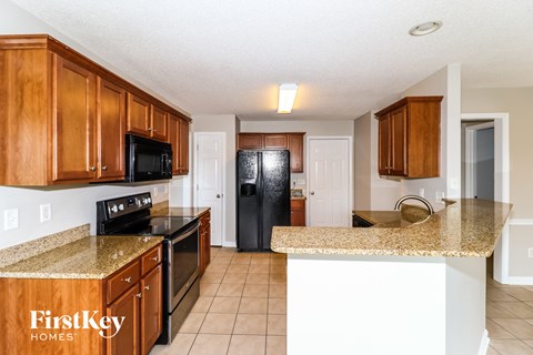 A kitchen with wooden cabinets and granite countertops.